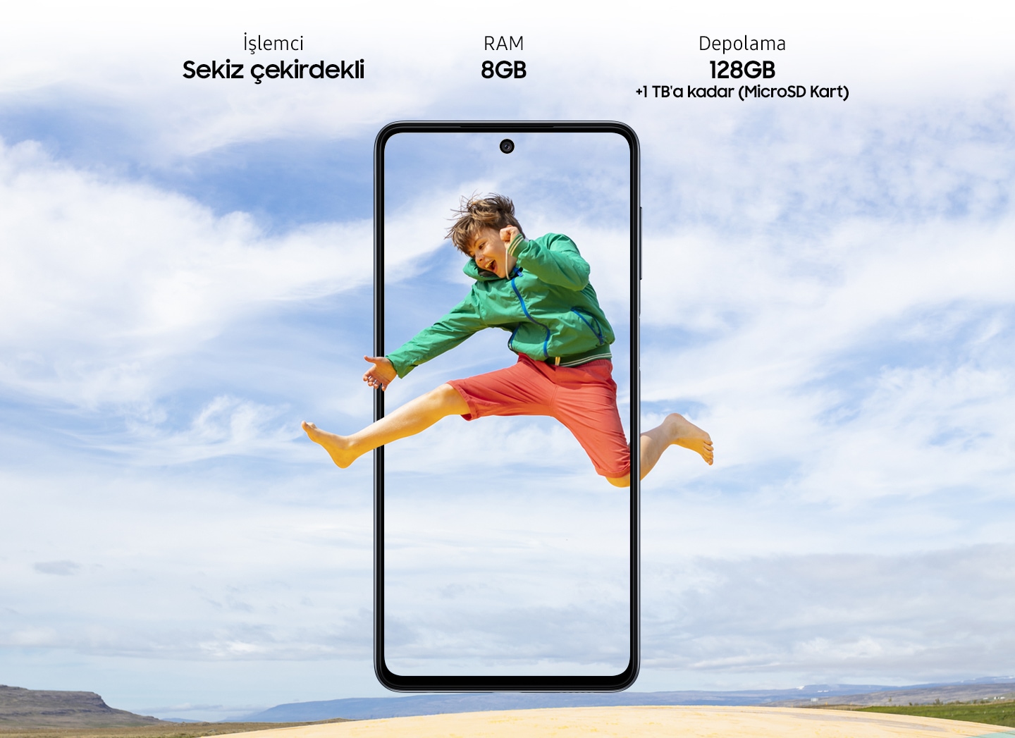 Galaxy M52 5G seen from the front. A playful girl jumping up in motion captured in a vertical M52 5G display and the big blue sky expands outside of the boundaries of the display.