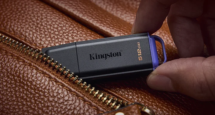 Kahverengi deri bir çantanın cebinde bir DataTraveler Exodia USB flash bellek.